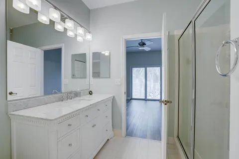 a bathroom with a double vanity sink mirror and shower