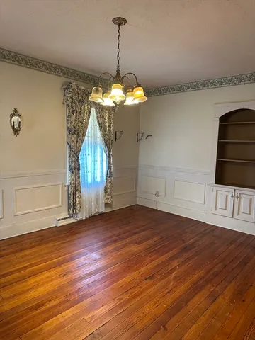 a view of a room with wooden floor and chandelier
