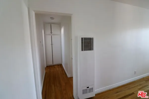 a view of a closet area with wooden floor