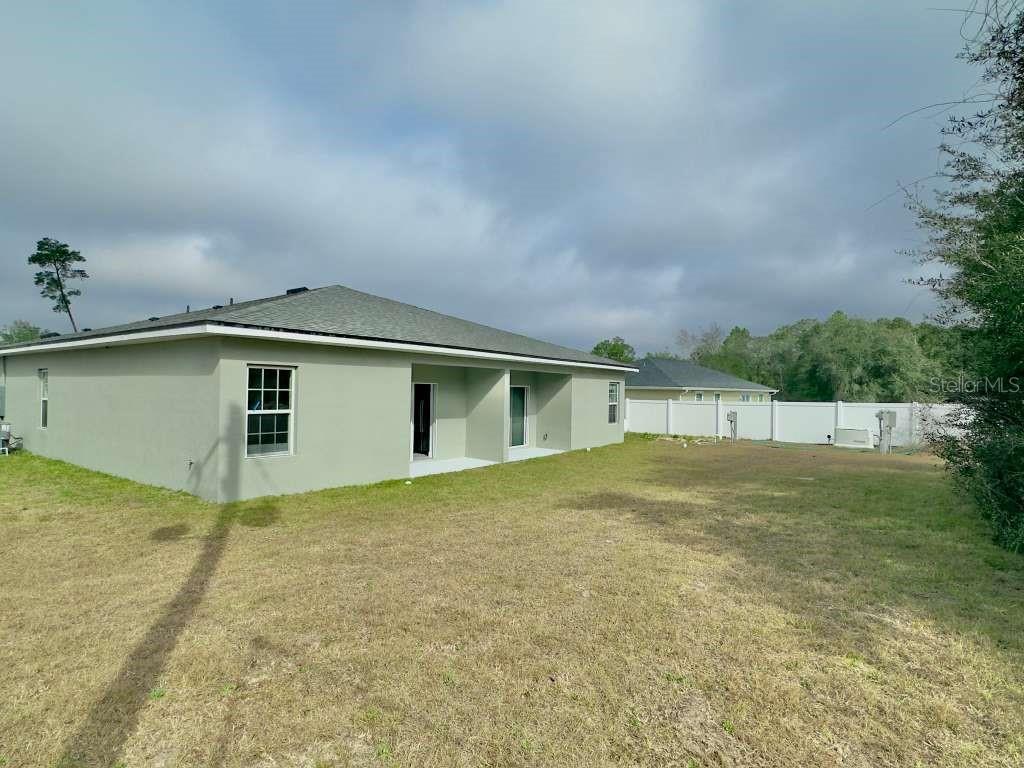 15885 Southwest 35th Court Road, Unit 1 Ocala, FL 34473 - Photo 25 of 27 a view of backyard of house and car parked
