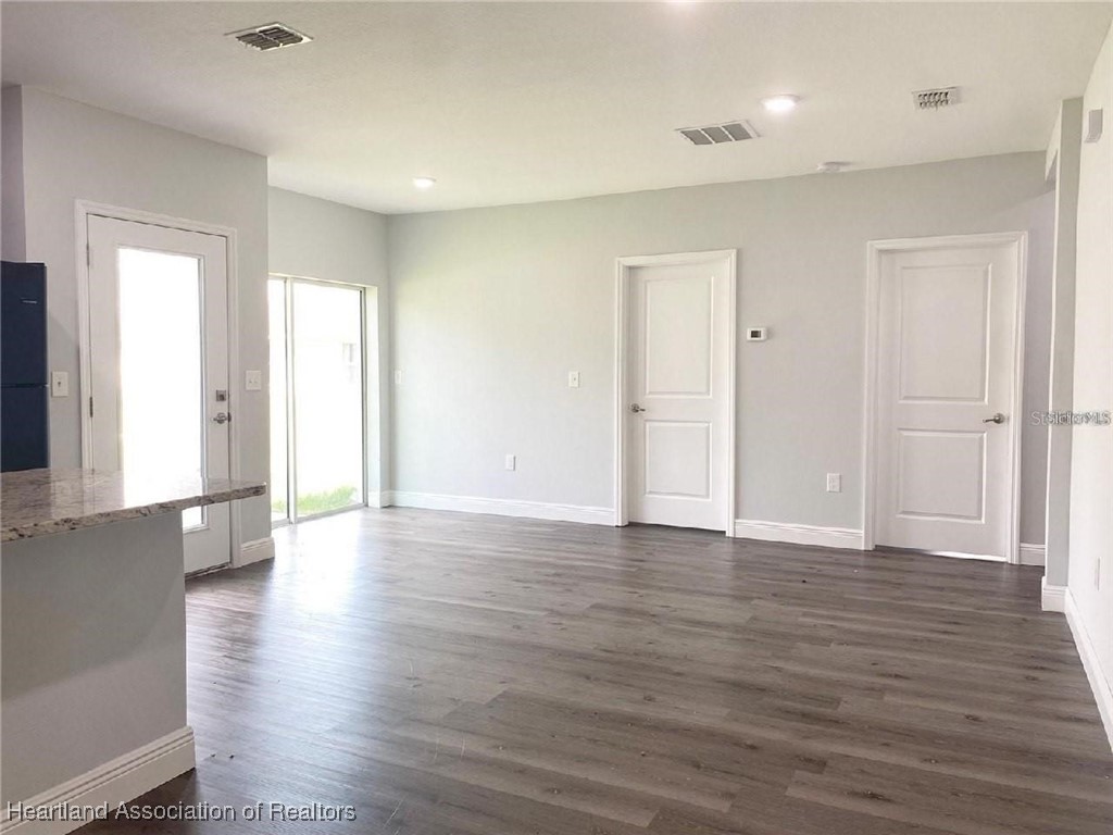 2115 Puffin Street, Unit 2115 Sebring, FL 33870 - Photo 2 of 7 a view of an empty room with wooden floor and a window