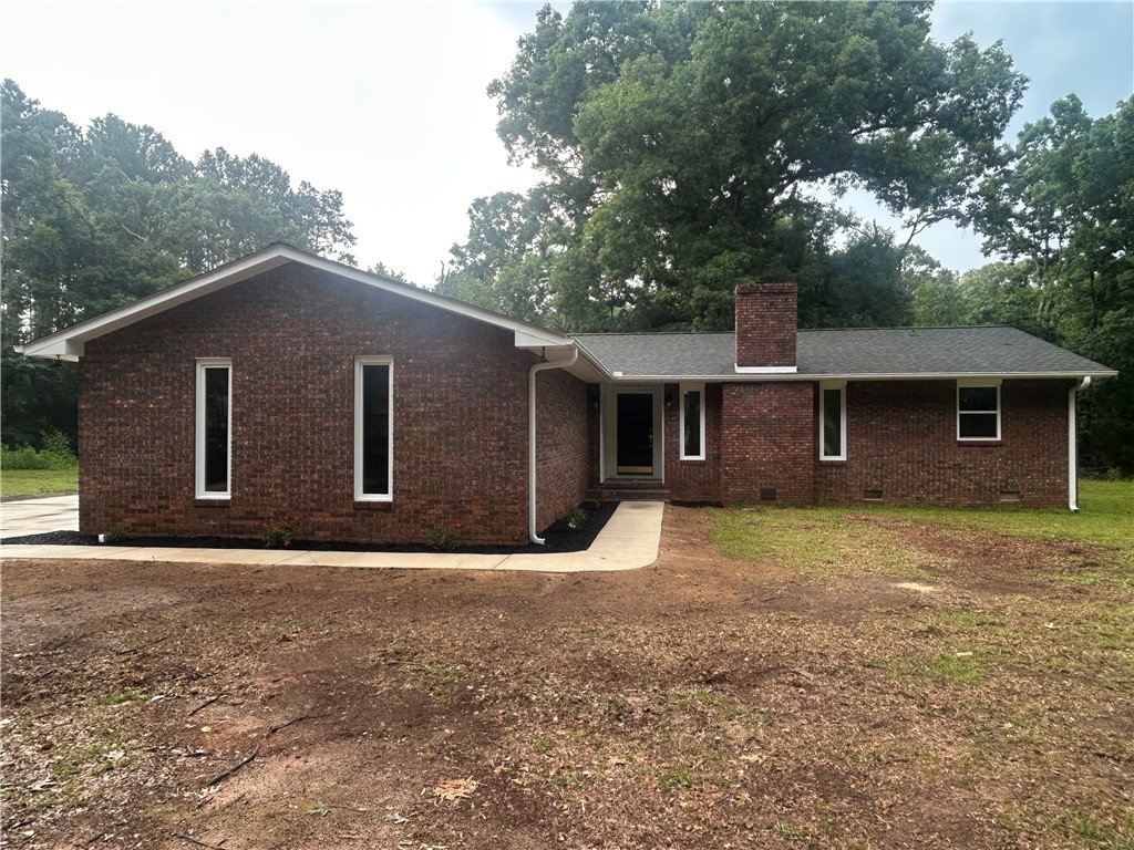 A classic brick exterior with a welcoming entryway, nestled among mature trees.