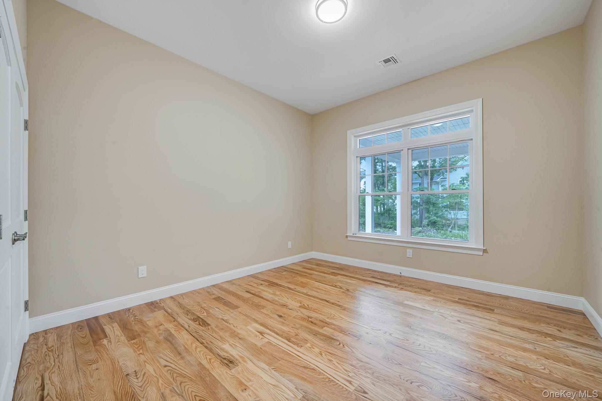 64 Blydenburgh Road Centereach, NY 11720 - Photo 16 of 29 a view of an empty room with wooden floor and a window