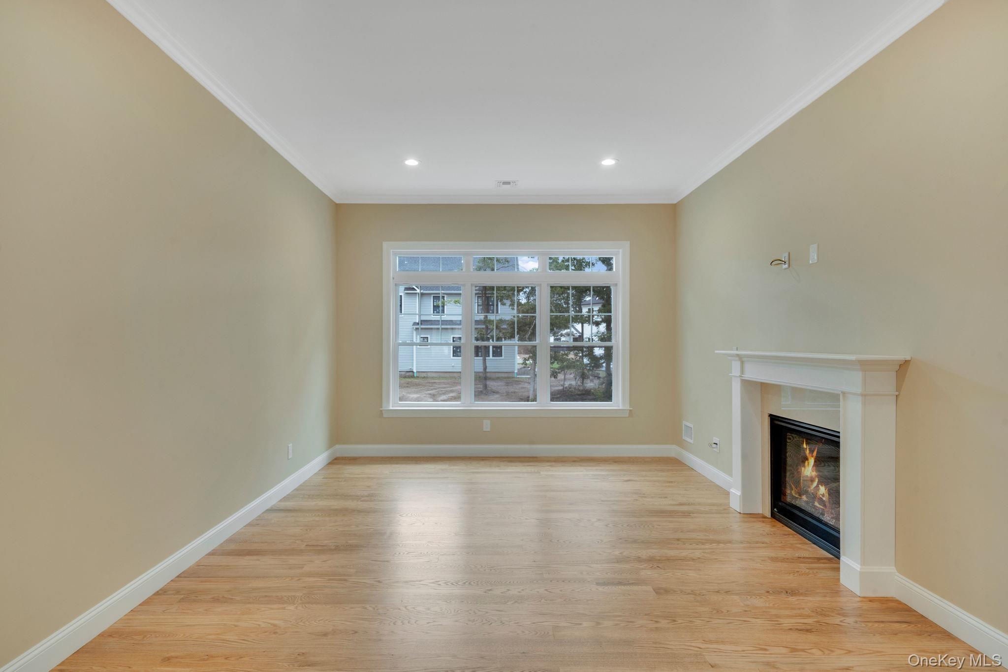 64 Blydenburgh Road Centereach, NY 11720 - Photo 7 of 29 a view of an empty room with wooden floor and a window