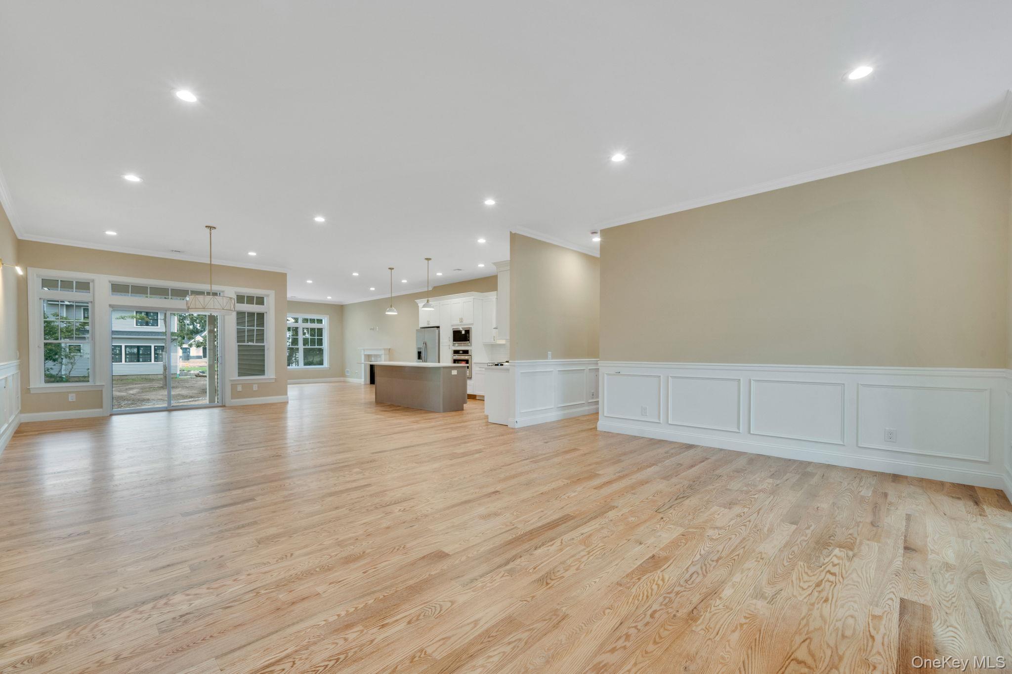 64 Blydenburgh Road Centereach, NY 11720 - Photo 8 of 29 a view of an empty room with wooden floor and a kitchen