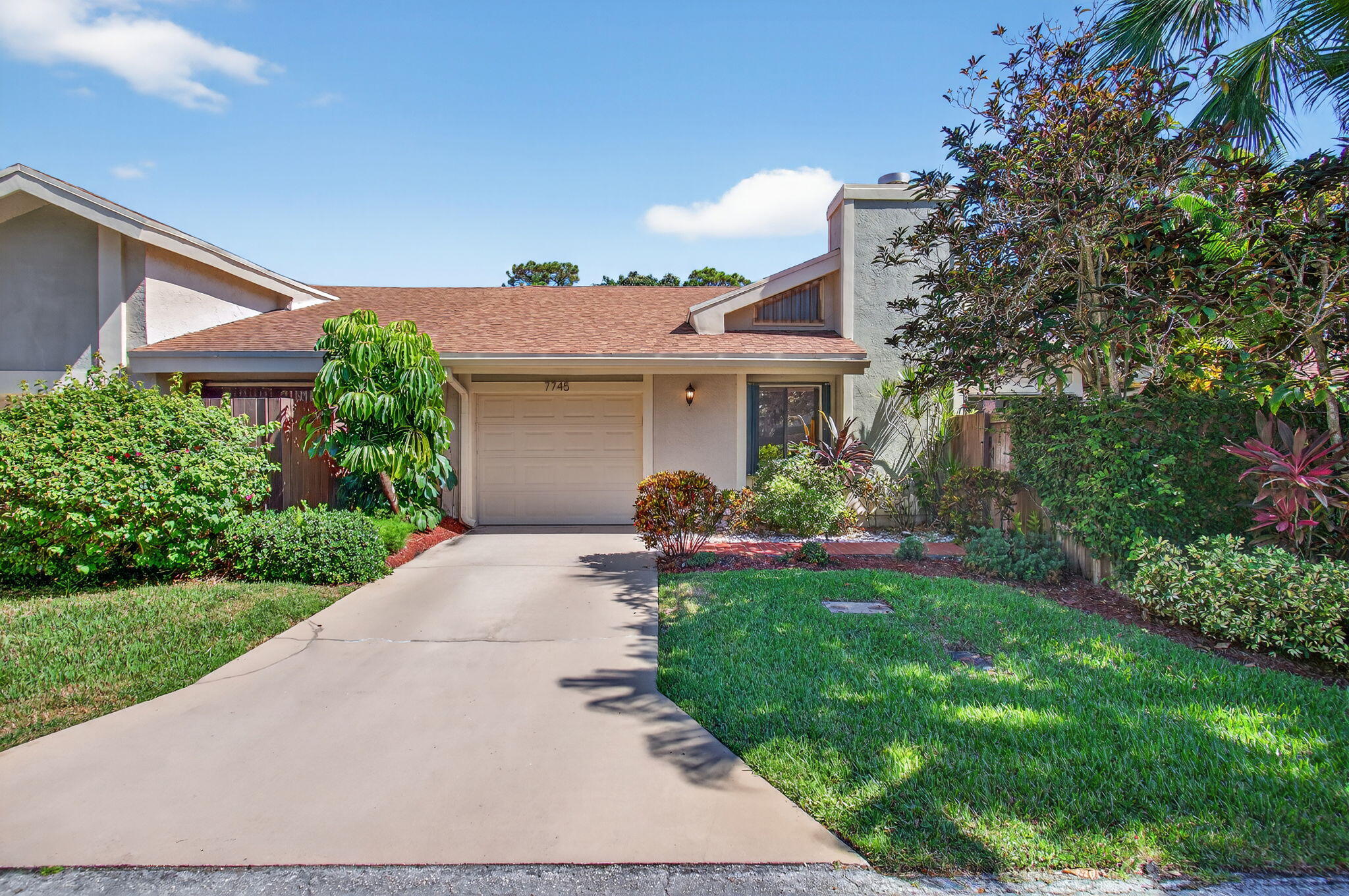 a front view of a house with a yard and potted plants