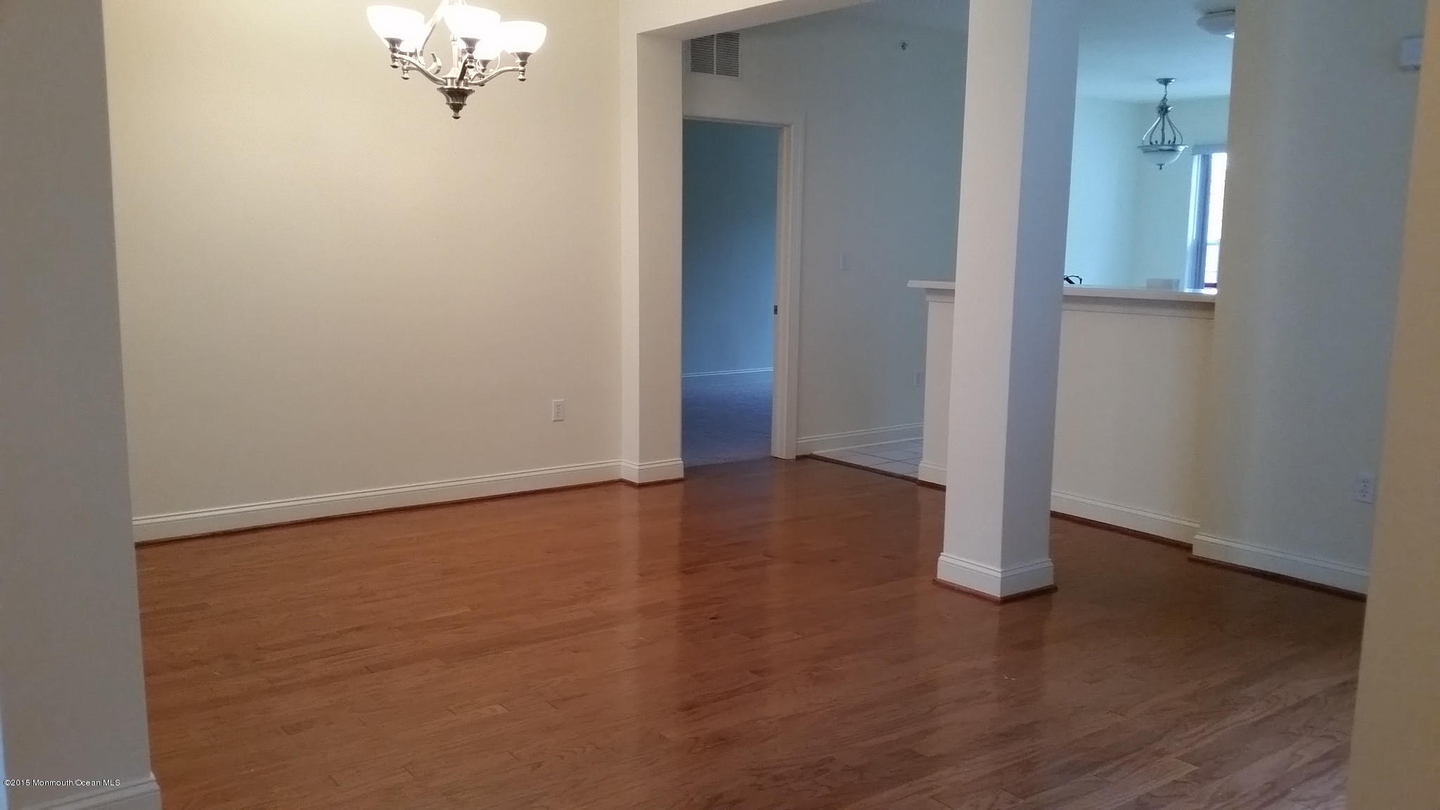 902 Abby Road Middletown, NJ 07748 - Photo 34 of 61 an empty room with wooden floor and mirror