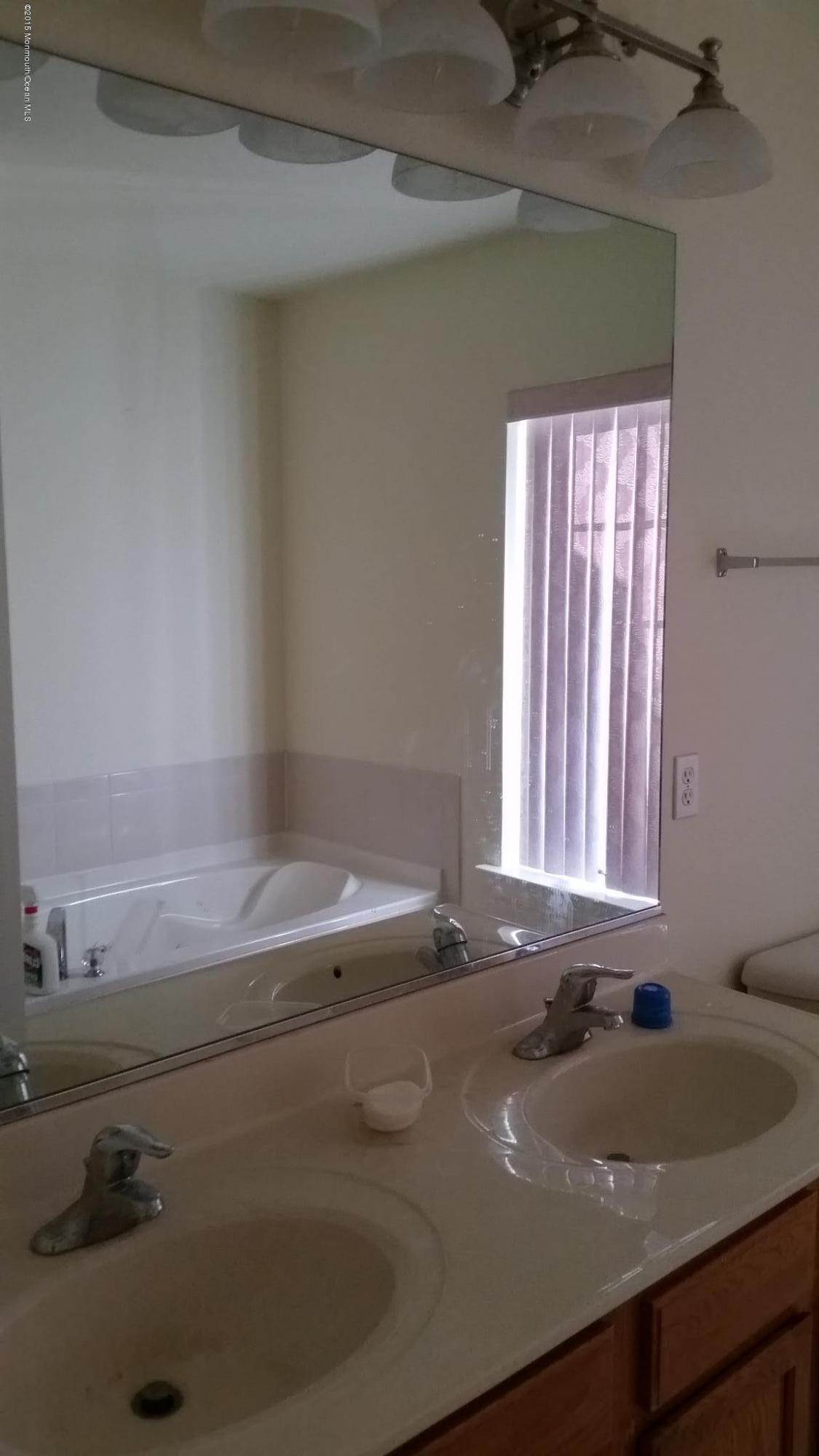 902 Abby Road Middletown, NJ 07748 - Photo 54 of 61 a bath tub sitting in a bathroom next to a sink