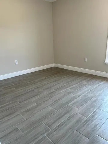 a view of an empty room with wooden floor