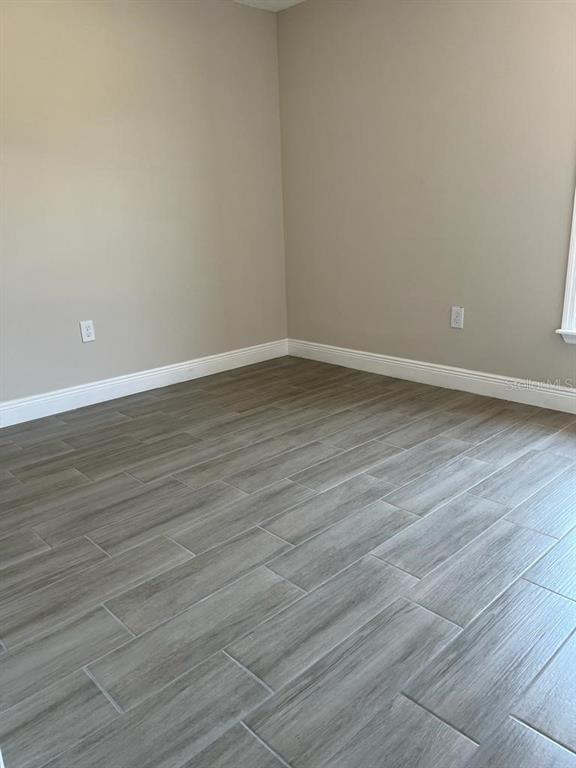 1042 Hickory Lane Cocoa, FL 32922 - Photo 5 of 8 a view of an empty room with wooden floor