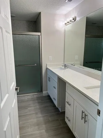 a bathroom with a double vanity sink and mirror