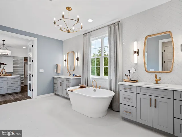 a spacious bathroom with a double vanity sink a mirror and a bathtub