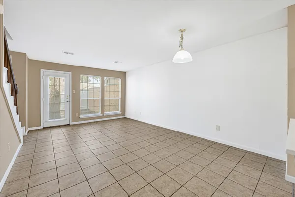 an empty room with windows and ceiling fan