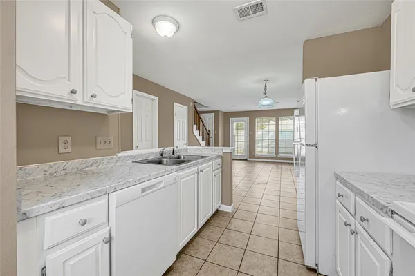 a kitchen with granite countertop a sink and cabinets