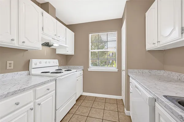a kitchen with granite countertop a stove sink and cabinets