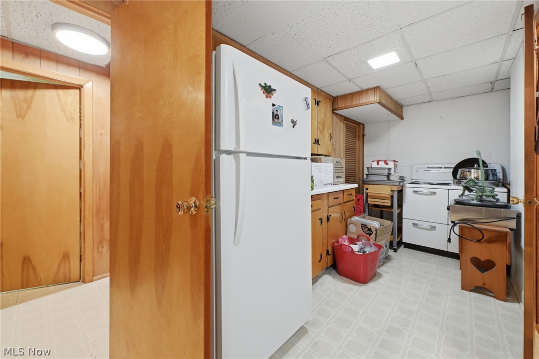 1499 Morris Road Kent, OH 44240 - Photo 29 of 41 Utility area featuring a white refrigerator, wood-finish cabinetry, and a white range