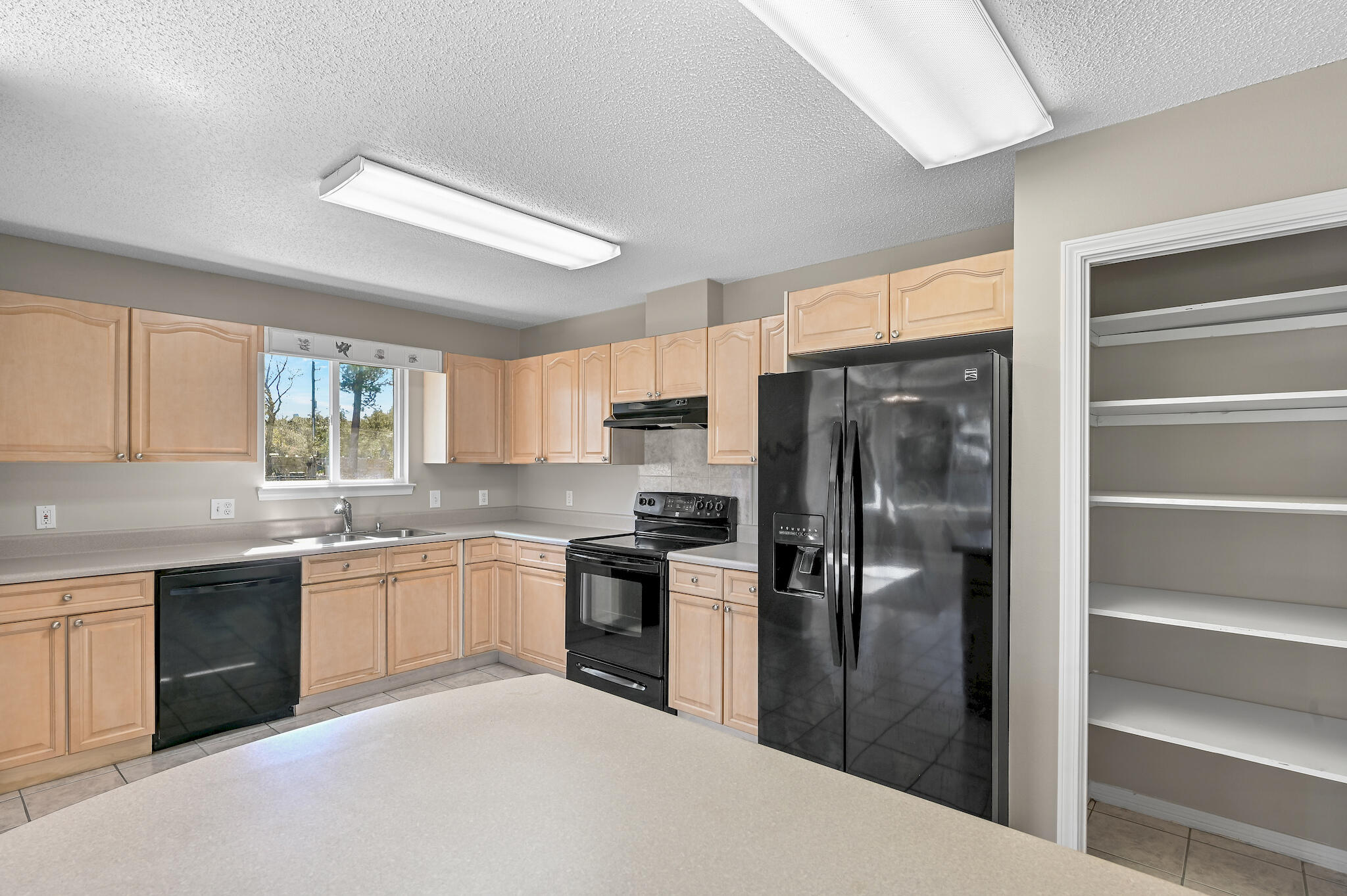 292 West Harborview Road Santa Rosa Beach, FL 32459 - Photo 13 of 43 a kitchen with stainless steel appliances granite countertop a refrigerator a sink a stove and white cabinets