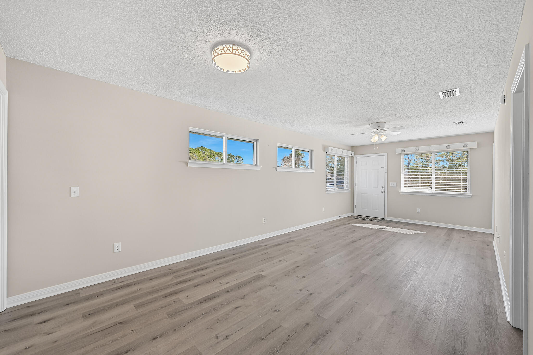 292 West Harborview Road Santa Rosa Beach, FL 32459 - Photo 27 of 43 an empty room with wooden floor and windows