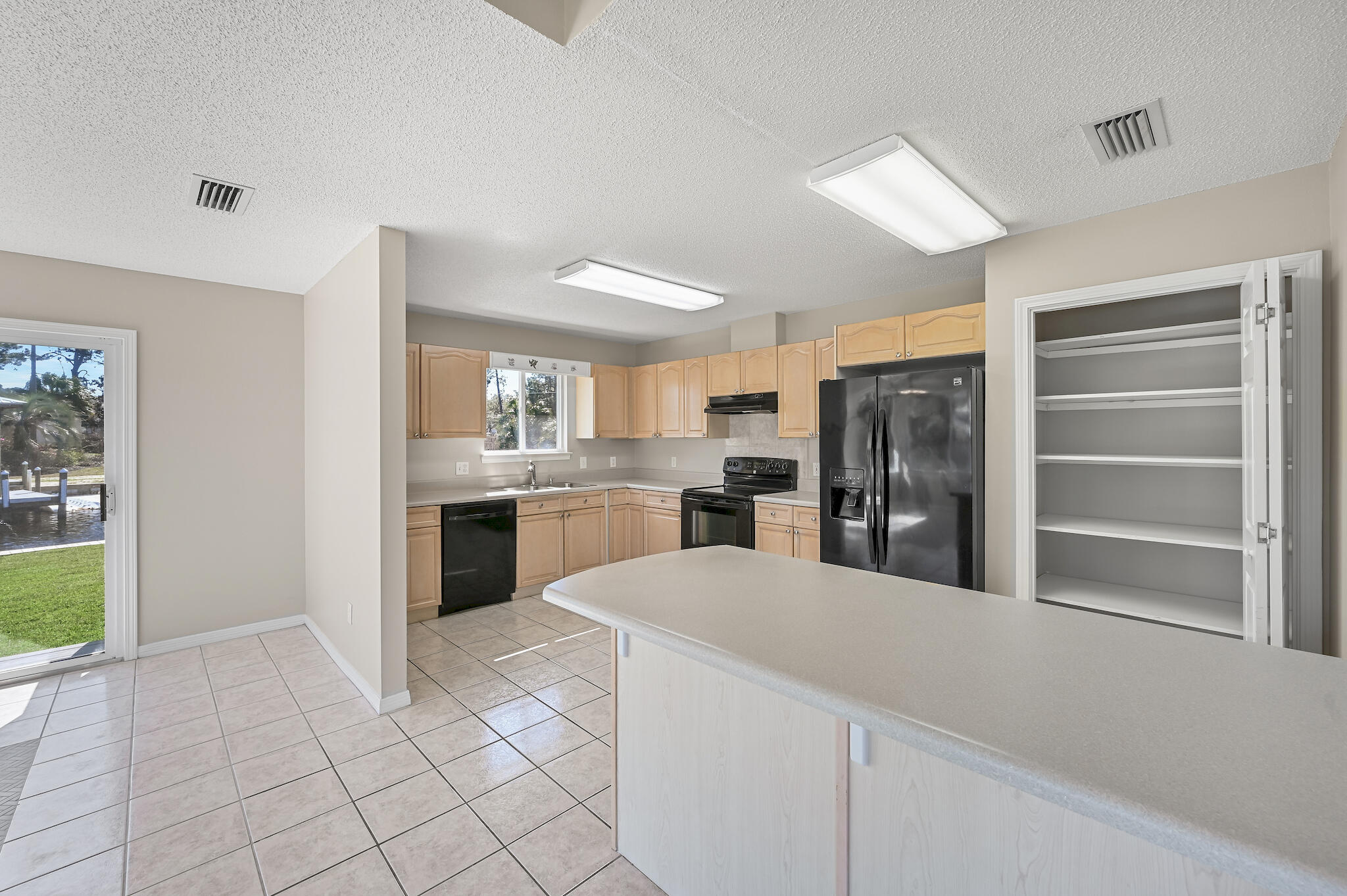 292 West Harborview Road Santa Rosa Beach, FL 32459 - Photo 8 of 43 a kitchen with granite countertop a refrigerator and a sink