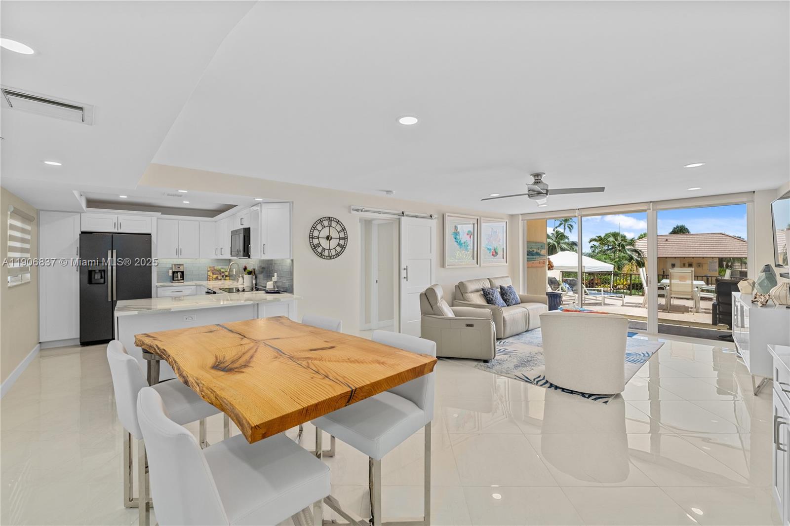 a living room with stainless steel appliances furniture and kitchen view