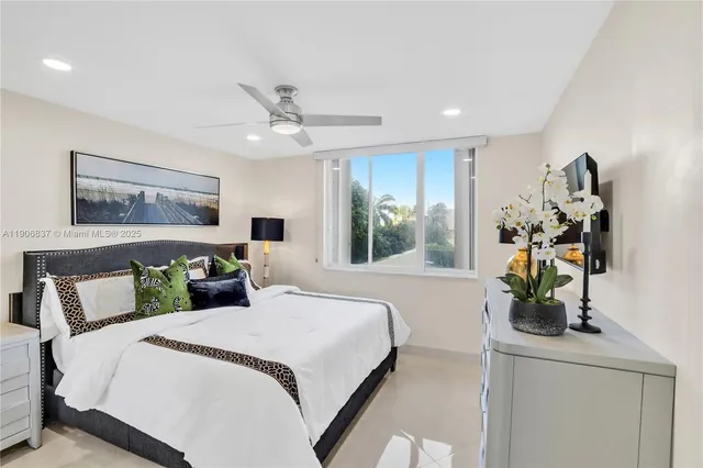 a bedroom with a bed potted plant on the dresser and a chandelier
