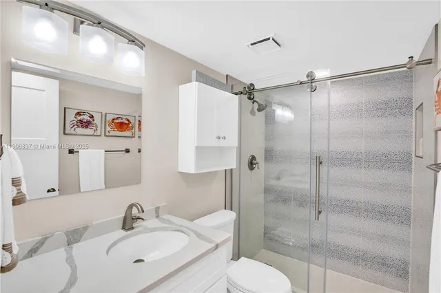 a bathroom with a shower sink vanity and toilet