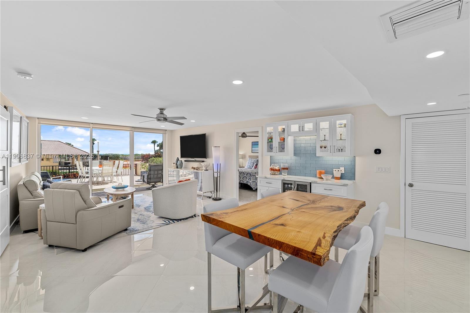 300 Ocean Trail Way, Unit 108 Jupiter, FL 33477 - Photo 2 of 21 a living room with kitchen island furniture and a table