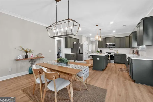 a kitchen with stainless steel appliances kitchen island granite countertop a kitchen island hardwood floor and a sink