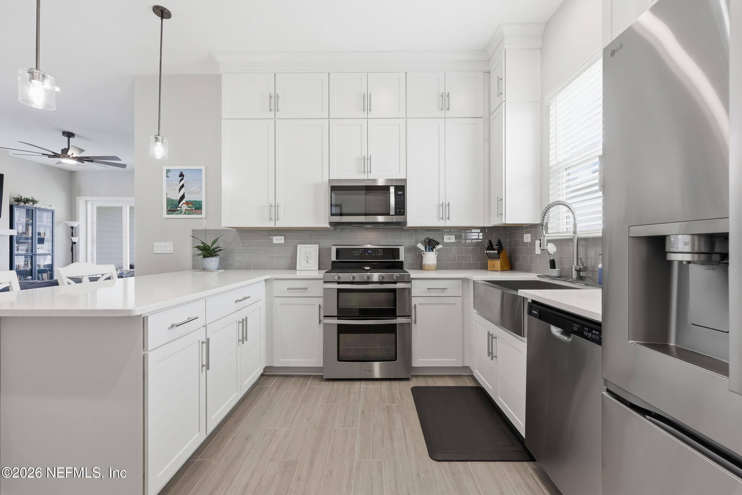 439 Rum Runner Way St. Johns, FL 32259 - Photo 19 of 82 a kitchen with granite countertop white cabinets and stainless steel appliances