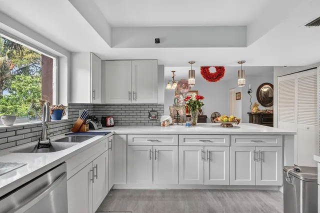 a kitchen with white cabinets and sink