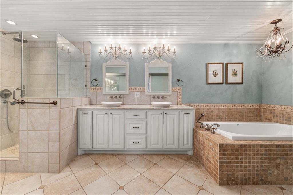 1929 Berkeley Place Fort Worth, TX 76110 - Photo 15 of 34 a bathroom with a double vanity sink a mirror and a bathtub