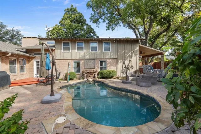 a view of a house with swimming pool and sitting area