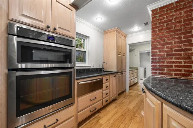 a kitchen with stainless steel appliances kitchen island granite countertop a stove microwave and sink