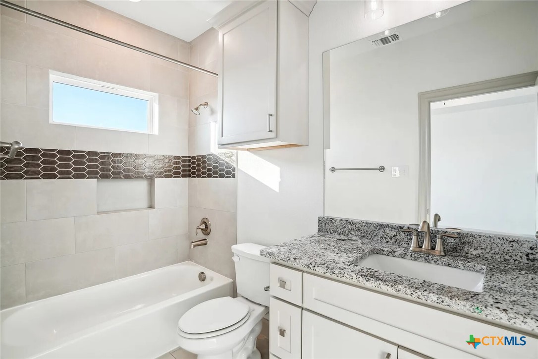 289 Star Grass, Unit 3 Spring Branch, TX 78070 - Photo 30 of 40 a bathroom with a granite countertop sink a toilet and bathtub