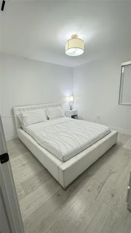 a bedroom with bed and a chandelier