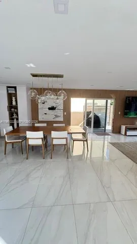 a dining room with furniture and a floor to ceiling window