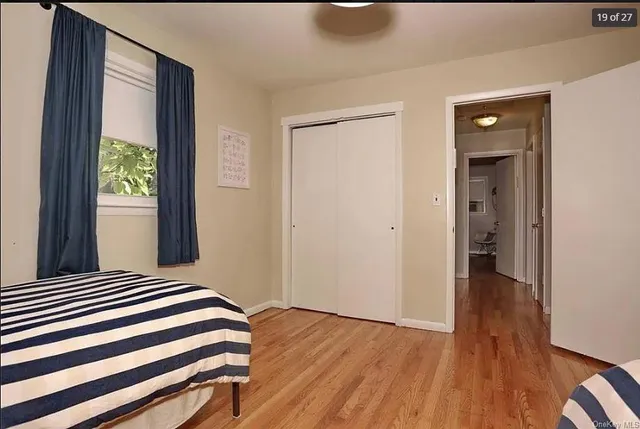 a view of a room with wooden floor and a window