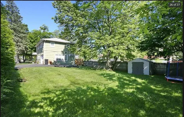 a view of a house with a yard and a tree