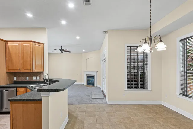 a view of kitchen with granite countertop cabinets and window