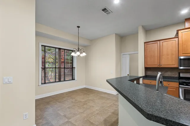 a kitchen with stainless steel appliances granite countertop a sink a stove and a granite counter tops