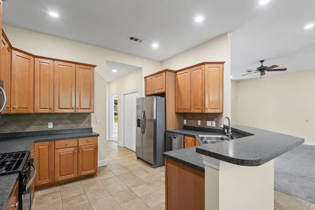a kitchen with stainless steel appliances granite countertop a sink refrigerator and cabinets
