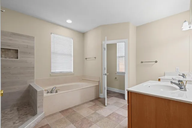 a bathroom with a tub sink and mirror