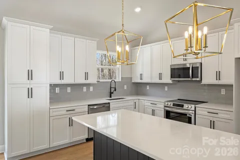 a kitchen with stainless steel appliances granite countertop a sink a stove and a refrigerator