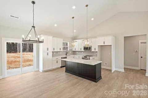 a large kitchen with kitchen island a stove a sink a refrigerator a center island a stove and a window