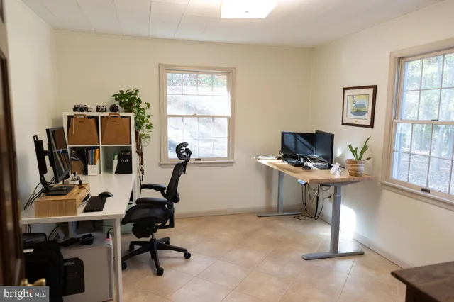a view of a workspace with furniture and a window