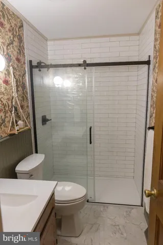 a bathroom with a shower a toilet and a sink