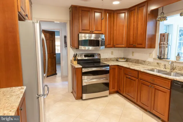a kitchen with granite countertop wooden cabinets and stainless steel appliances