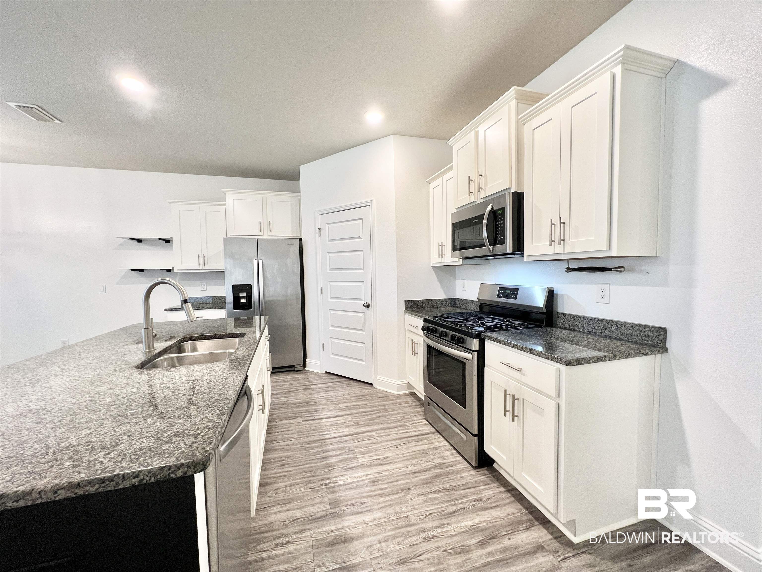 24785 Slater Mill Road Daphne, AL 36526 - Photo 9 of 46 Kitchen featuring sink, appliances with stainless steel finishes, white cabinets, and light hardwood / wood-style floors