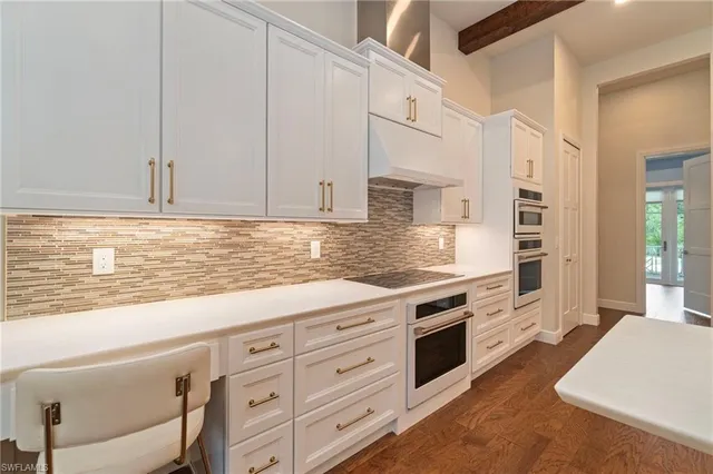 a kitchen with granite countertop white cabinets and white appliances