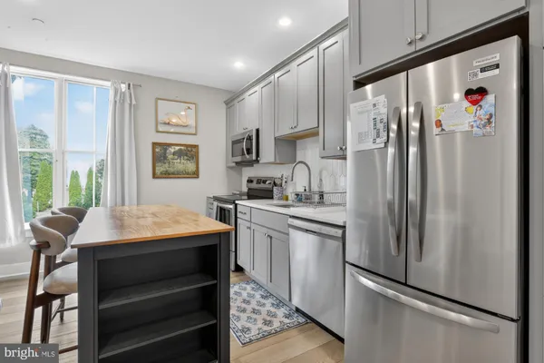 a kitchen with stainless steel appliances granite countertop a refrigerator and a stove top oven